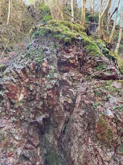 赤みを帯びた岩場から水が滴る&nbsp;